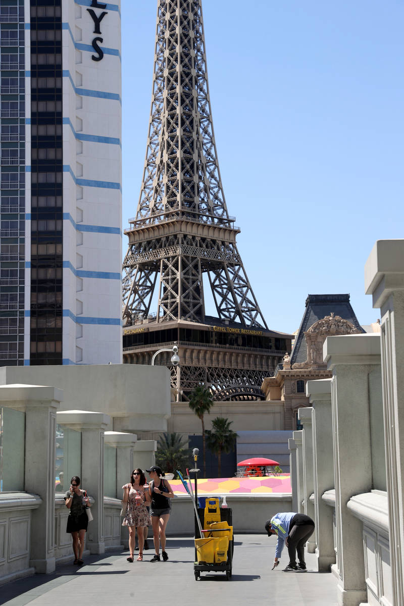 A worker cleans the pedestrian bridge connecting The Cromwell to BallyÕs on the Strip in L ...