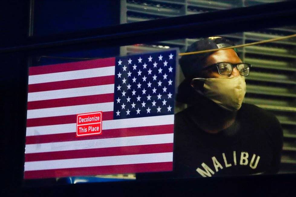 A protester who was arrested waits in the back of a bus during a rally at the Barclays Center o ...