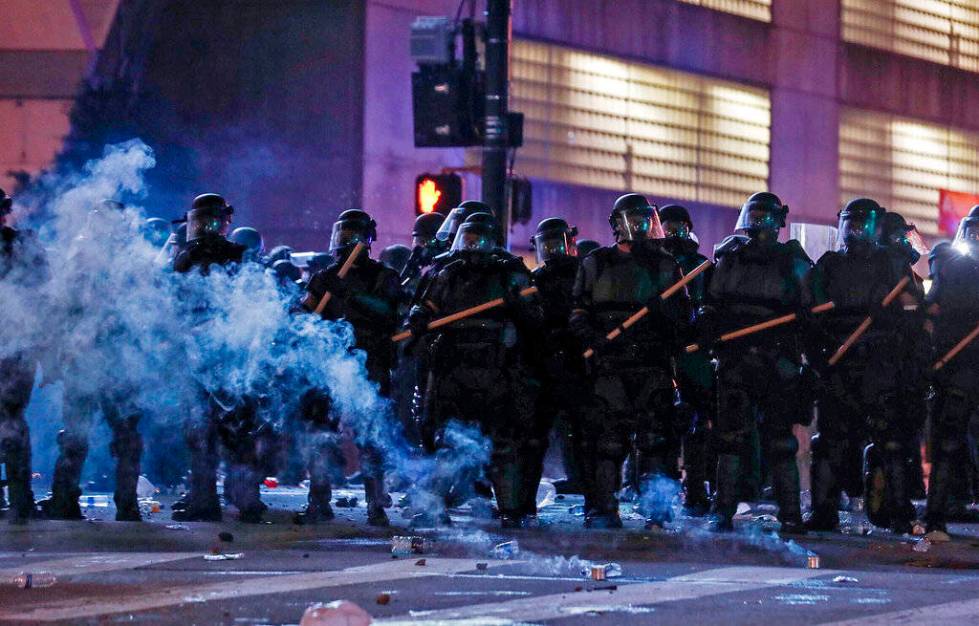 Police in riot gear form a line near the Centennial Olympic Park and CNN center where some conf ...