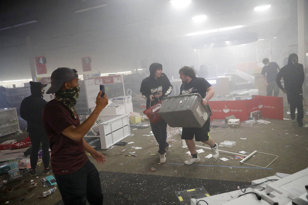 People enter a looted Office Depot Friday, May 29, 2020, in Minneapolis. Protests continued fol ...