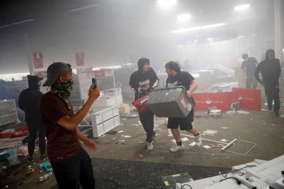 People enter a looted Office Depot Friday, May 29, 2020, in Minneapolis. Protests continued fol ...