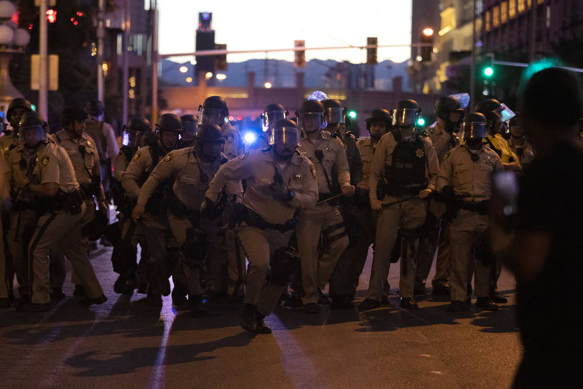 Las Vegas police officers run toward the crowd of protesters who took the Las Vegas Strip in su ...