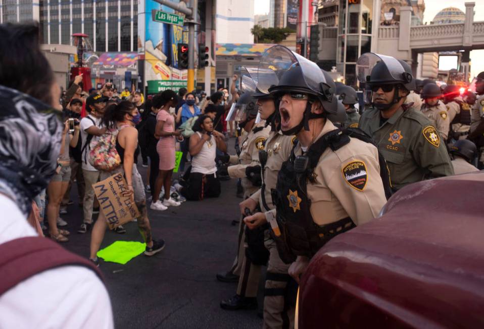 A Las Vegas police officer screams at protesters to back up as the protest moves down Flamingo ...