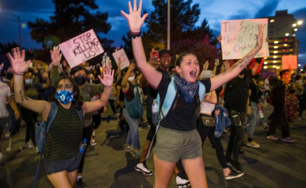 Protesters yell "Hands up, don't shoot" to police nearby as they march up 7th Street ...