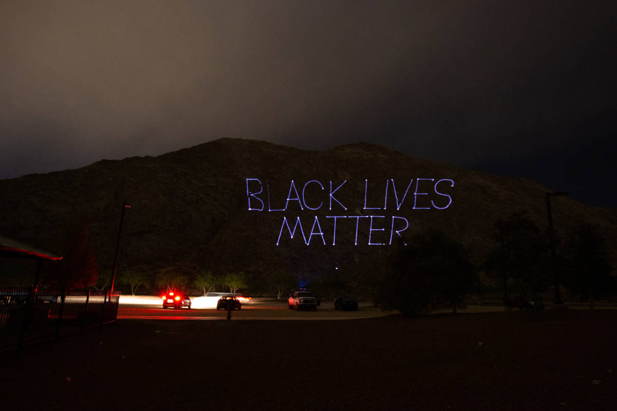 "Black Lives Matter" is projected onto the side of Lone Mountain by the company Tag Team Produc ...