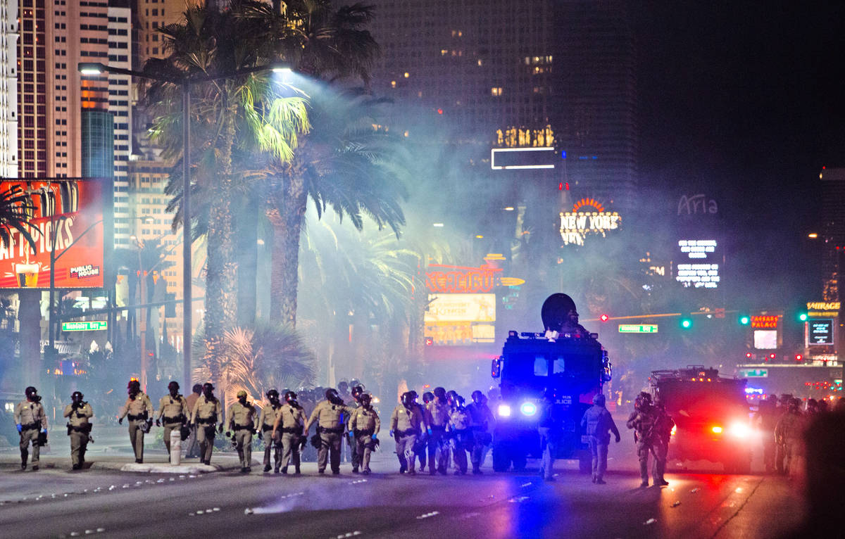 Las Vegas police officers deploy tear gas on protesters on the Strip on Sunday, May 31, 2020, i ...