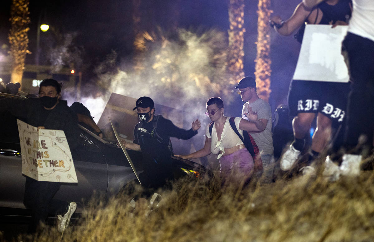 Protesters run after Las Vegas police fire tear gas and pepper bullets during a Black Lives Mat ...