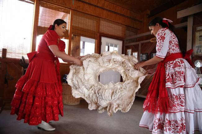 Viridiana, left, and her sister Alondra Colon, shape a crinoline to hold out their dresses befo ...