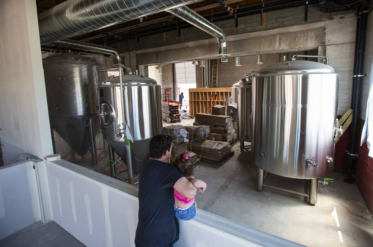 Jason Taylor, with daughter Ariana, 3, looks over work done at Nevada Brew Works during constru ...