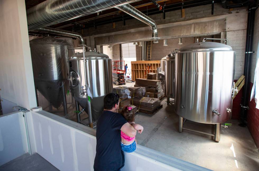Jason Taylor, with daughter Ariana, 3, looks over work done at Nevada Brew Works during constru ...