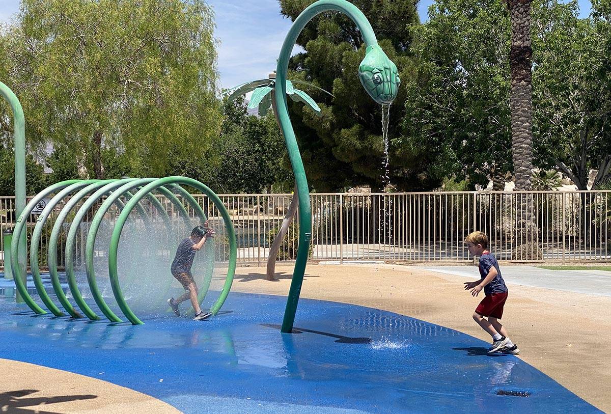 Children running through sprinklers at Aliante Nature Discovery Park's splash pad as it reopene ...