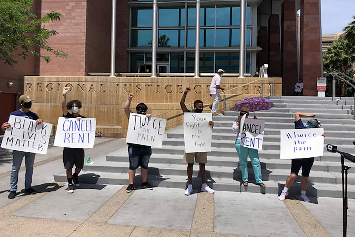 Eight people, some wearing Make The Road Nevada T-shirts, stood outside the Regional Justice Ce ...
