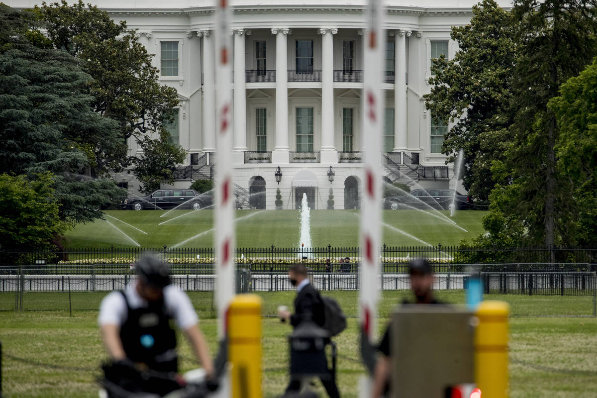 The White House is visible as uniformed Secret Service agents stand at a checkpoint on Constitu ...