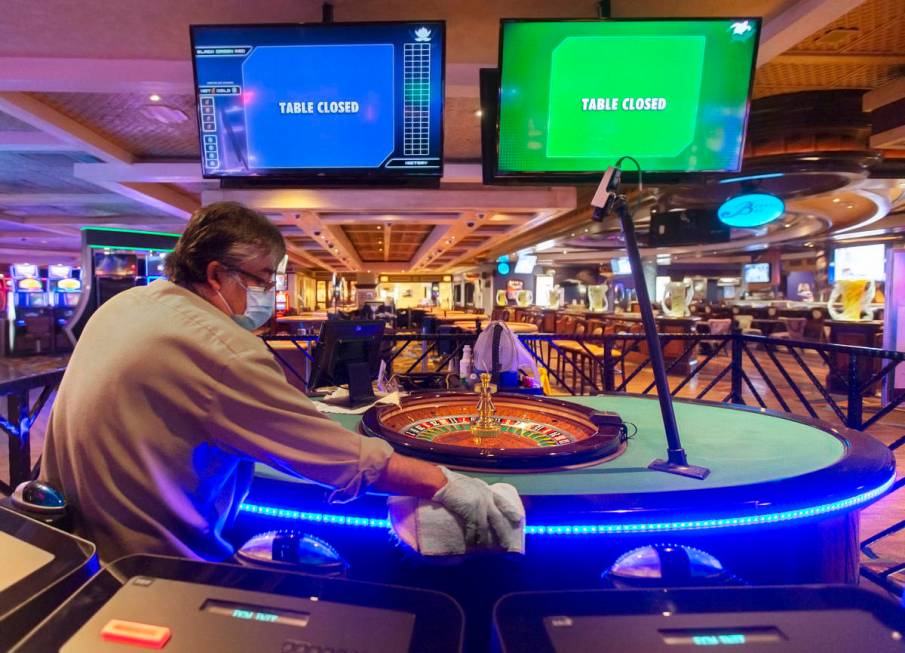 Manuel Mendellin sanitizes a roulette table at TI on Monday, June 1, 2020, in Las Vegas. (Benja ...