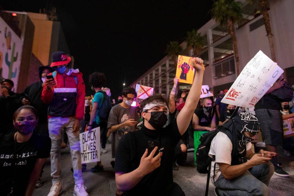 Protesters for George Floyd and against police brutality face police in a peaceful demonstratio ...