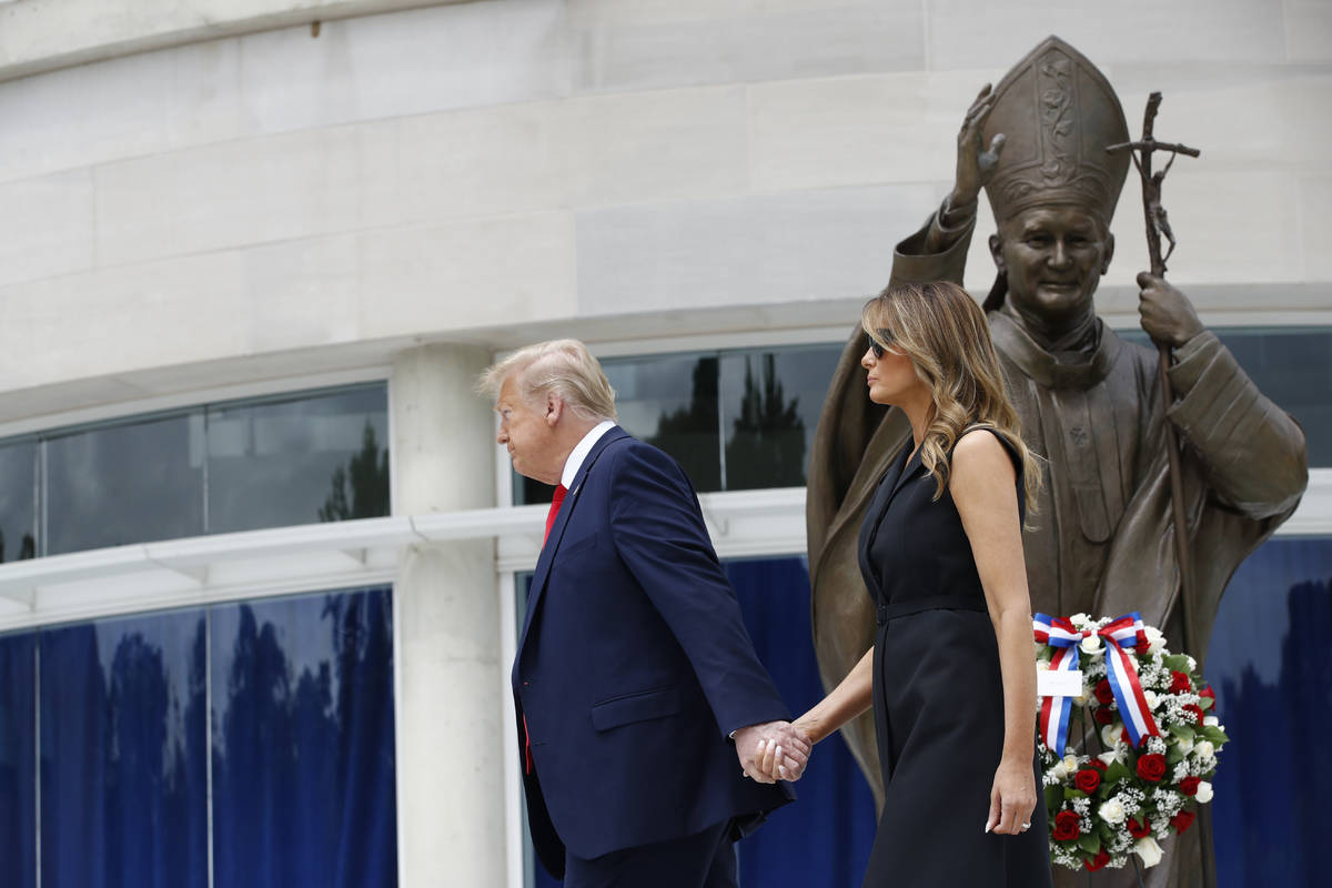 President Donald Trump holds first lady Melania Trump's hand as they visit Saint John Paul II N ...