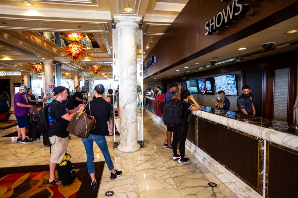 Guests line up while social distancing for check-in at the Golden Nugget in downtown Las Vegas ...