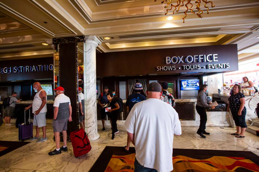 Guests line up while social distancing for check-in at the Golden Nugget in downtown Las Vegas ...