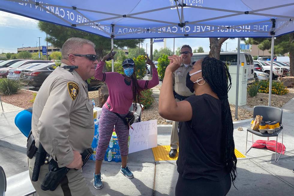 Simone Hall, right, and Demetria Williams, center, stop to thank Las Vegas police outside Unive ...