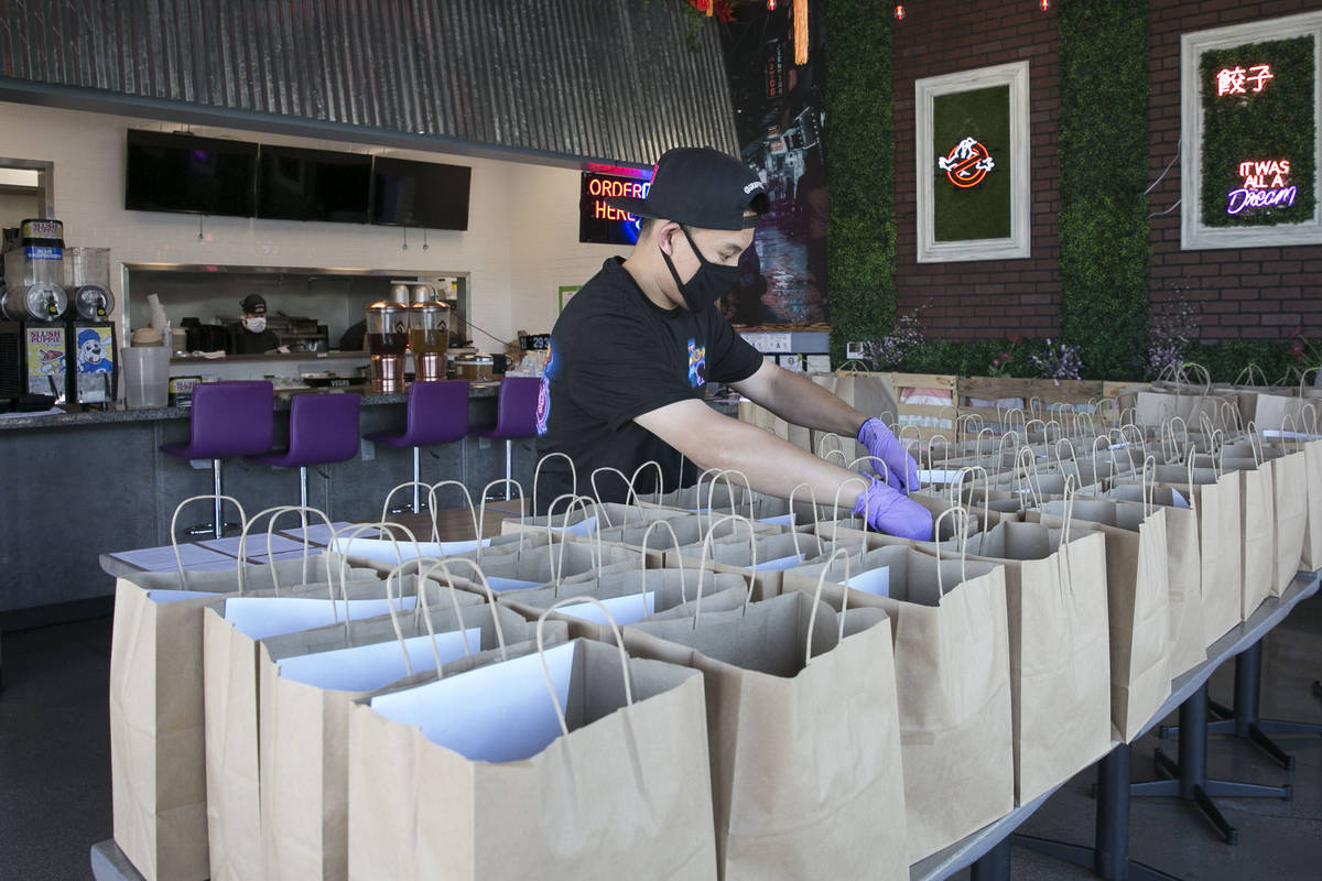 Ronald Duong, employee at Graffiti Bao restaurant, prepares bags of food to be delivered on Fri ...