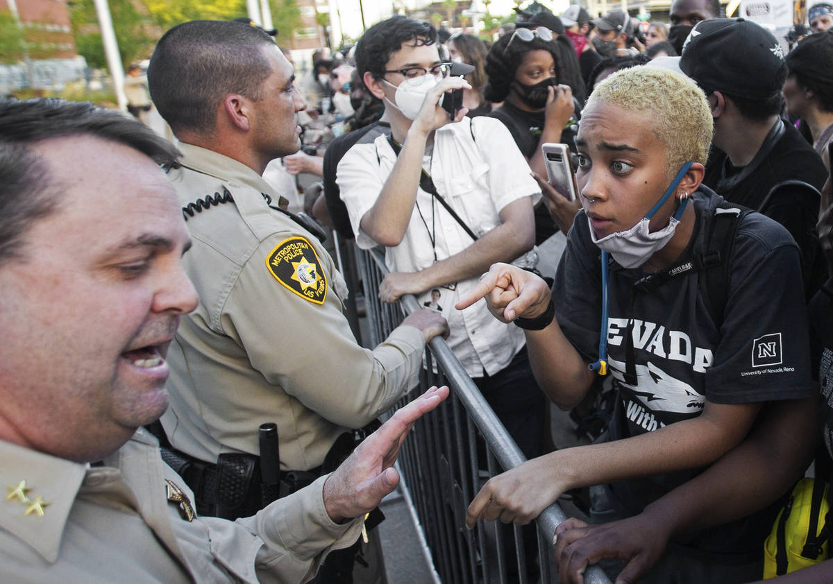 A protester has a heated discussion with assistant sheriff Christopher Jones, bottom/left, outs ...