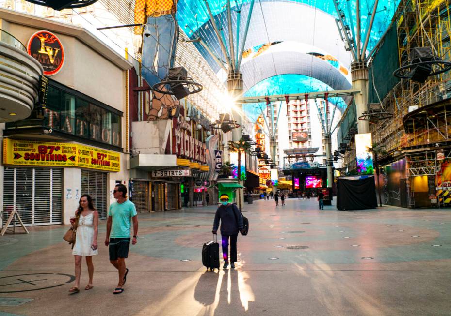 People walk around the Fremont Street Experience as hotel-casinos reopen in downtown Las Vegas ...