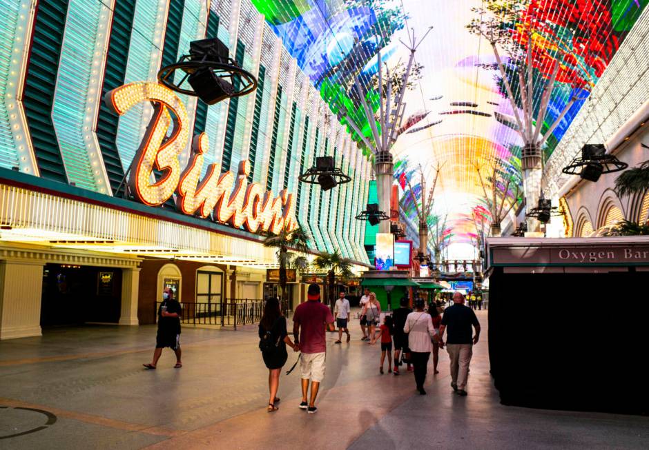 People walk around the Fremont Street Experience as hotel-casinos reopen in downtown Las Vegas ...