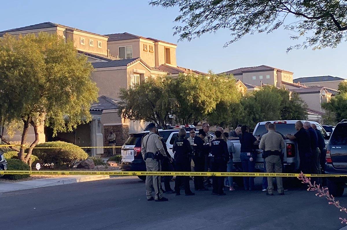 Las Vegas police officers gather at the scene of a homicide in the 8800 block of Canyon Saddle ...