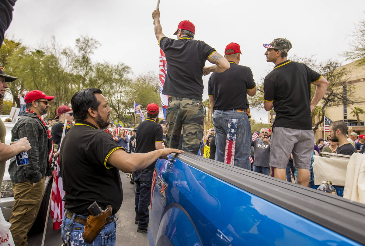 Proud Boys stand atop of a truck and welcome all to enter as Reopen Nevada holds a protest agai ...