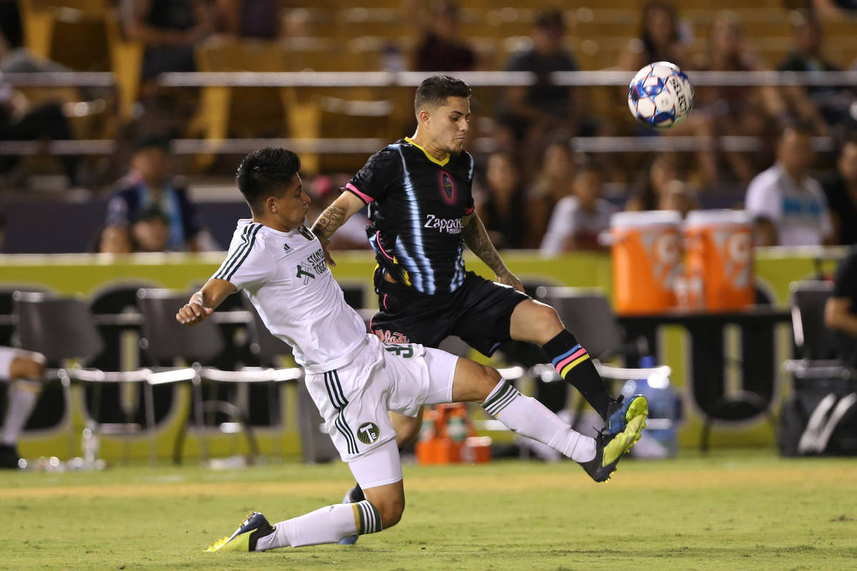 Las Vegas Lights' Raul Mendiola (40) fights for the ball against Portland Timbers' Marco Farfan ...