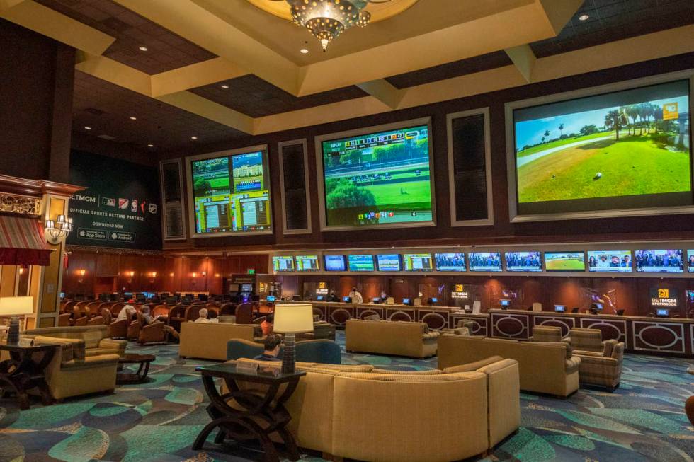 Individuals wait for a horse race to begin on the reopening of the Bellagio sportsbook, Thursda ...