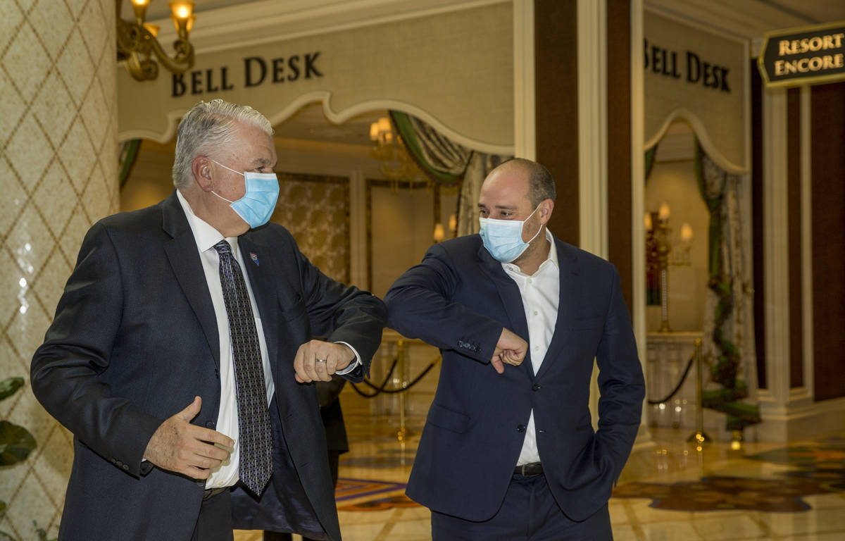 Gov. Steve Sisolak, left, and Wynn Las Vegas CEO Matt Maddox bump elbows during a tour to view ...