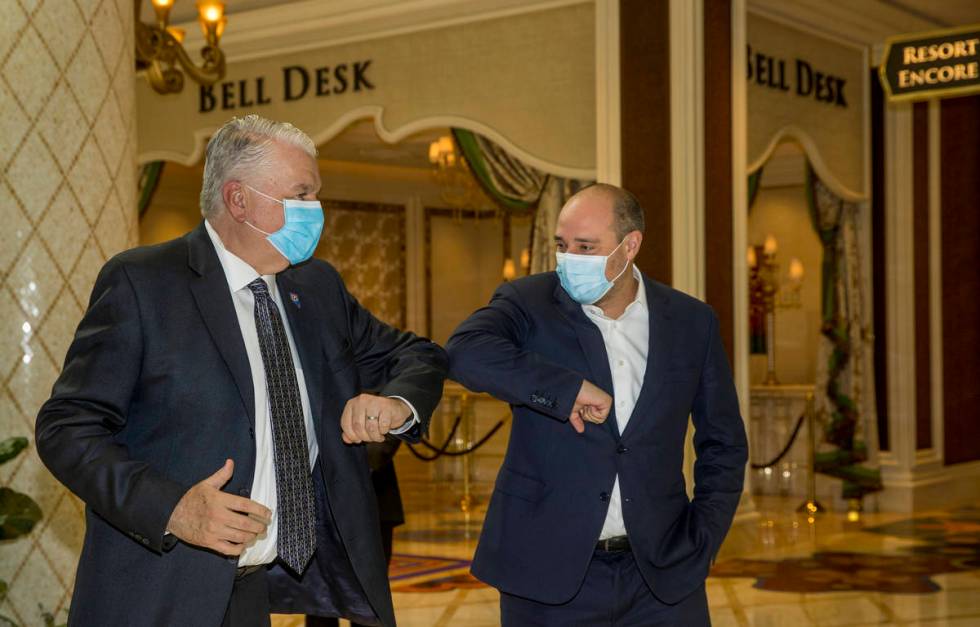 Gov. Steve Sisolak, left, and Wynn Las Vegas CEO Matt Maddox bump elbows during a tour to view ...