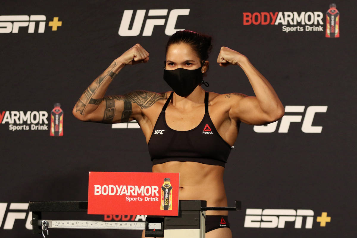 UFC women's featherweight champion Amanda Nunes poses on the scale at the UFC Apex after making ...