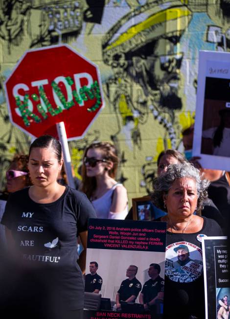 Marie Cofinco, of Orange County, Calif., holds up signs showing her nephew Fermin Valenzuela, a ...