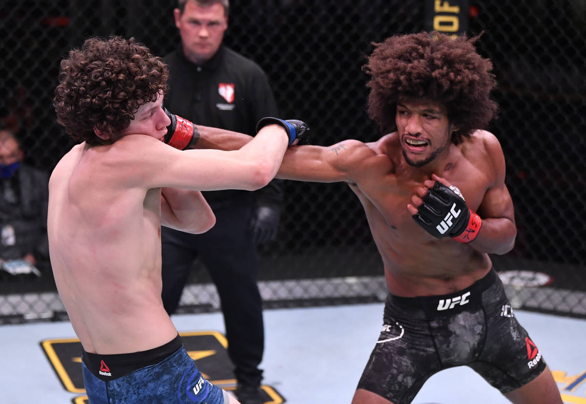 LAS VEGAS, NEVADA - JUNE 06: (R-L) Alex Caceres punches Chase Hooper in their featherweight bou ...