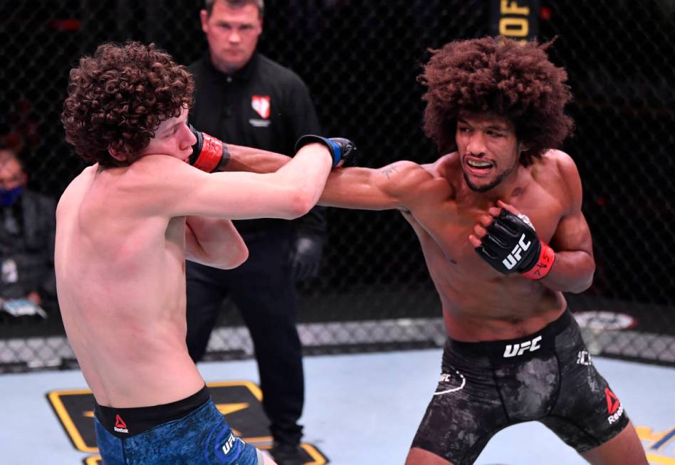 LAS VEGAS, NEVADA - JUNE 06: (R-L) Alex Caceres punches Chase Hooper in their featherweight bou ...