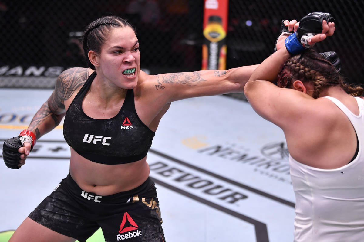 Amanda Nunes, left, of Brazil punches Felicia Spencer of Canada in their featherweight champion ...