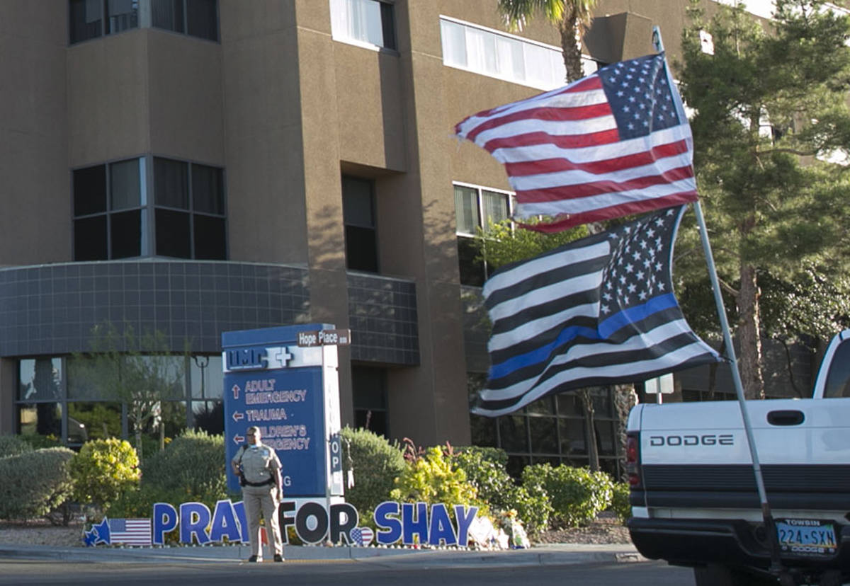 A driver in a pick up truck waving a large American Flag drives past University Medical Center ...