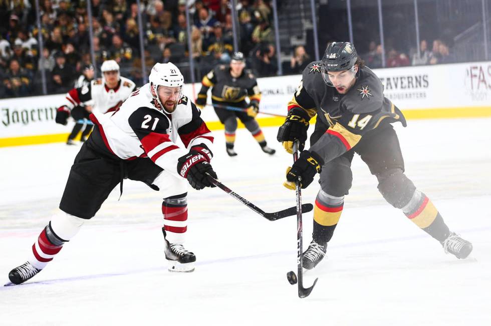 Golden Knights' Nicolas Hague (14) moves the puck around Arizona Coyotes' Derek Stepan (21) dur ...