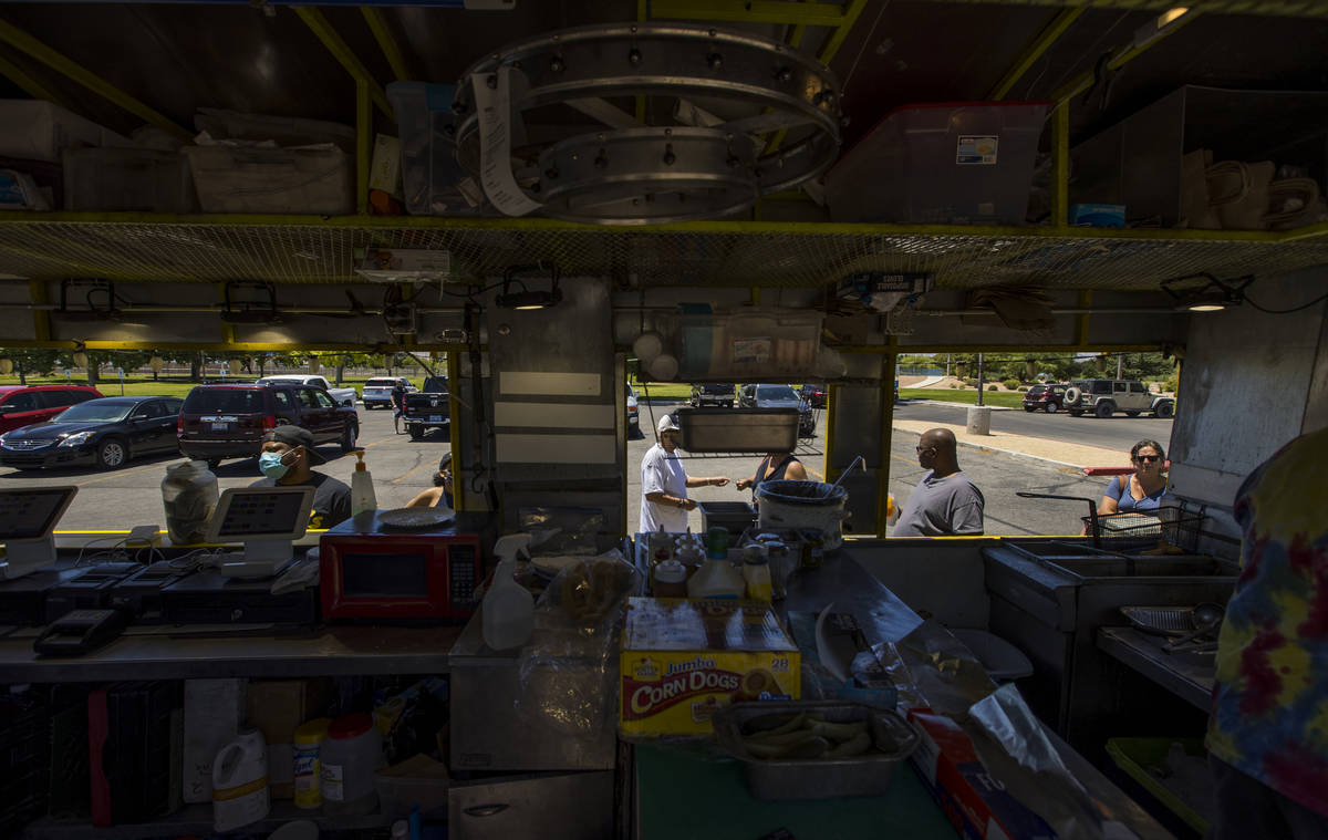 Customers await their orders outside the Hot Diggity Dog Las Vegas food truck while parked abou ...