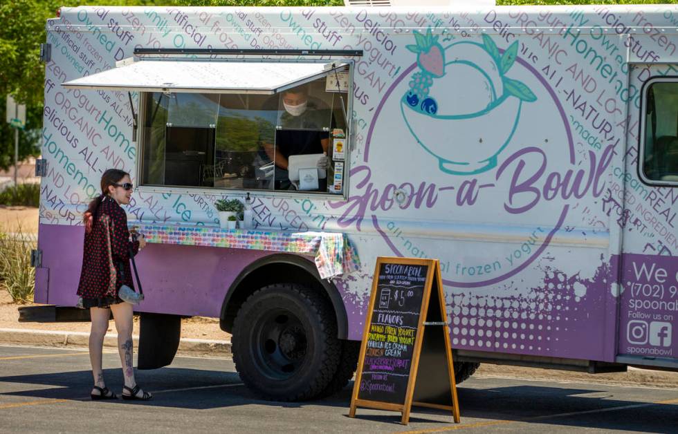 A customer awaits her dessert from the Spoon-a-Bowl food truck parked about the Desert Breeze C ...