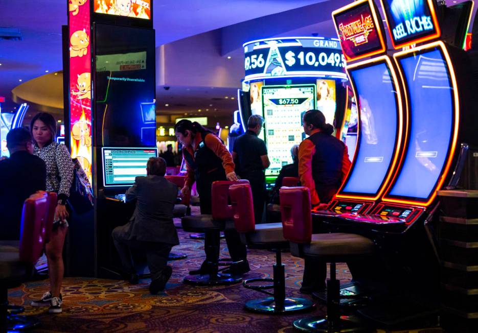 Slot attendants help shut down machines shortly before midnight at the Luxor in Las Vegas on Mo ...