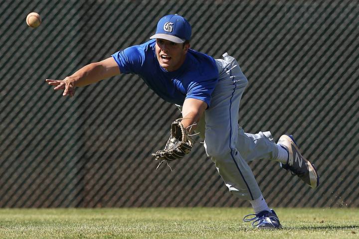 Bishop Gorman senior Austin Wells dives for a ball during practice on Monday, April 16, 2018, a ...