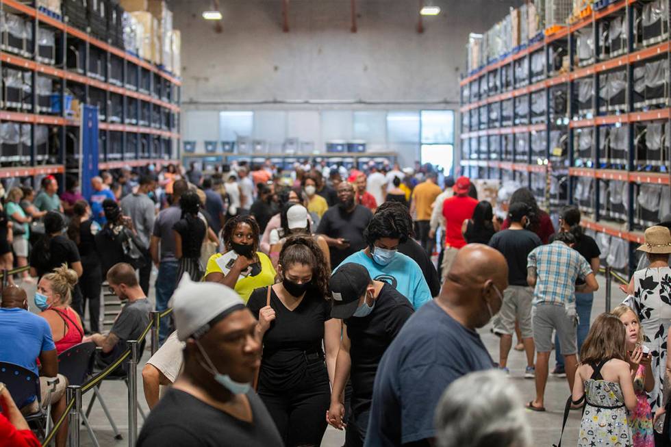 Voters wait in line to submit their ballots during the state’s first all-mail primary at ...