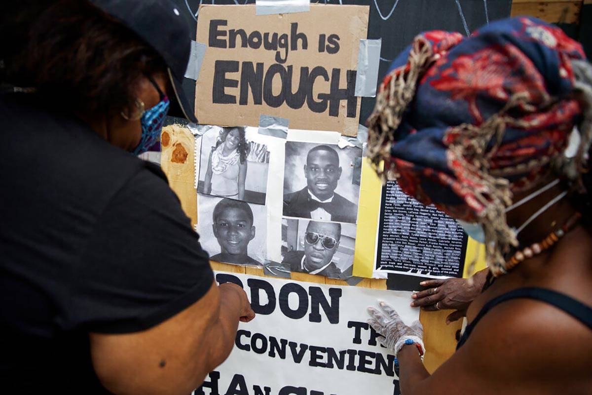 Wendy Long, left, and Sister Mamie, repost signs that were removed form the Lafayette Park para ...