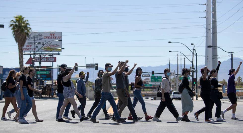 Demonstrators cross Charleston Boulevard on their way to Las Vegas City Hall in an effort to de ...