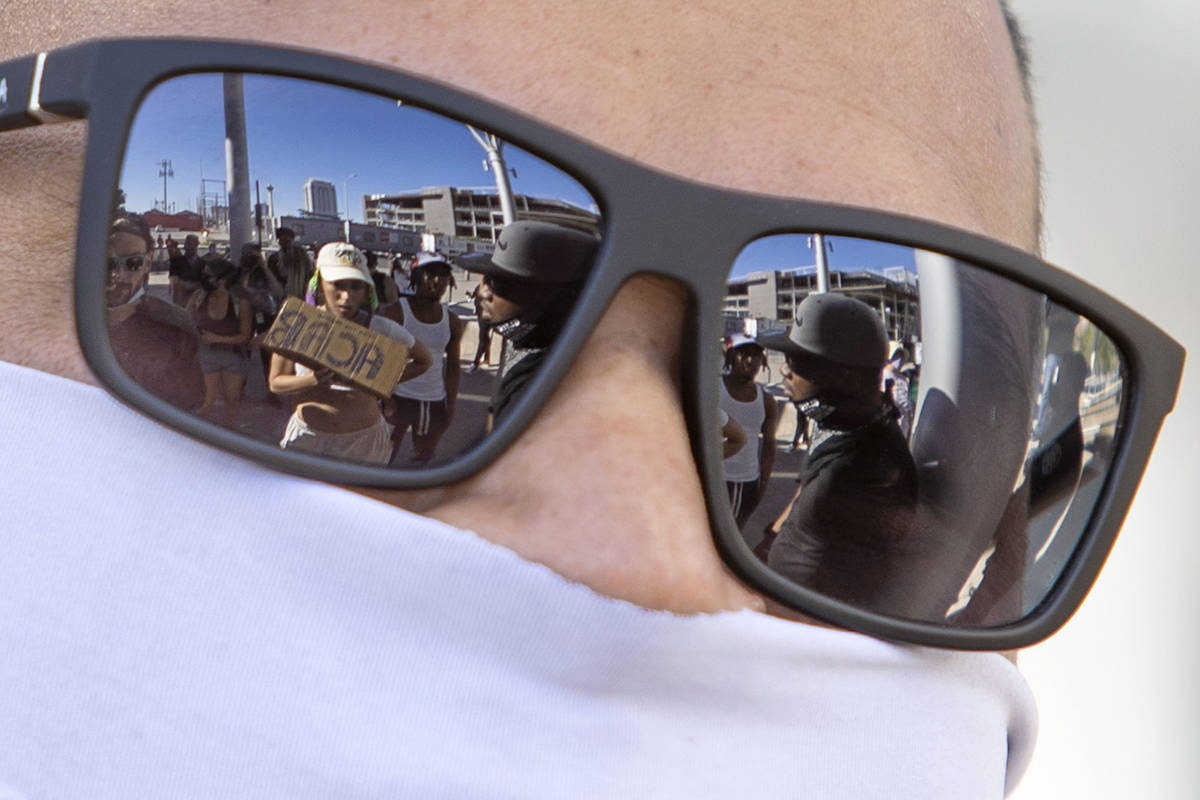Demonstrators are reflected in the sunglasses of a Las Vegas police officer outside Las Vegas C ...