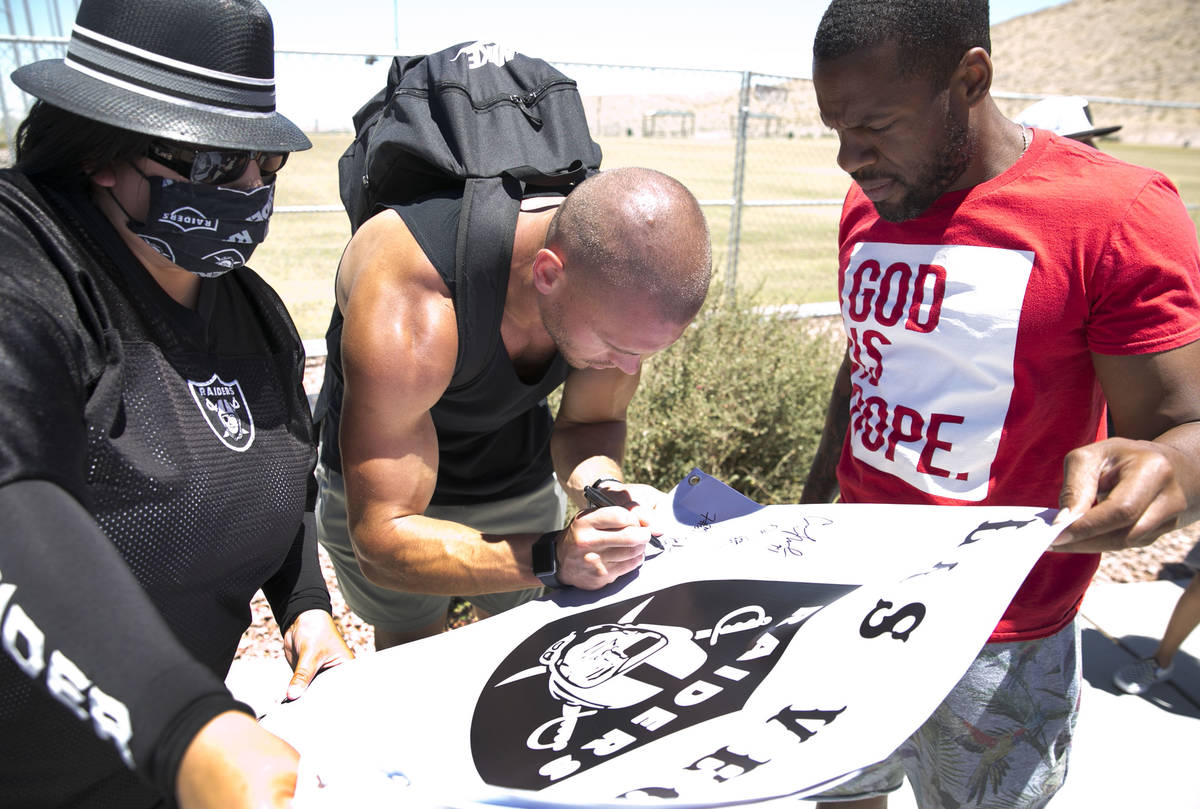 The Las Vegas Raiders tight end Derek Carrier signs an autograph for Cynthia Ie, left, of Las V ...