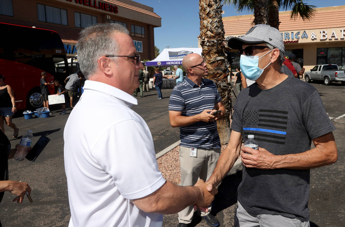 Guy Mikalonis, right, father of Las Vegas police officer Shay Mikalonis gets support from Bob L ...
